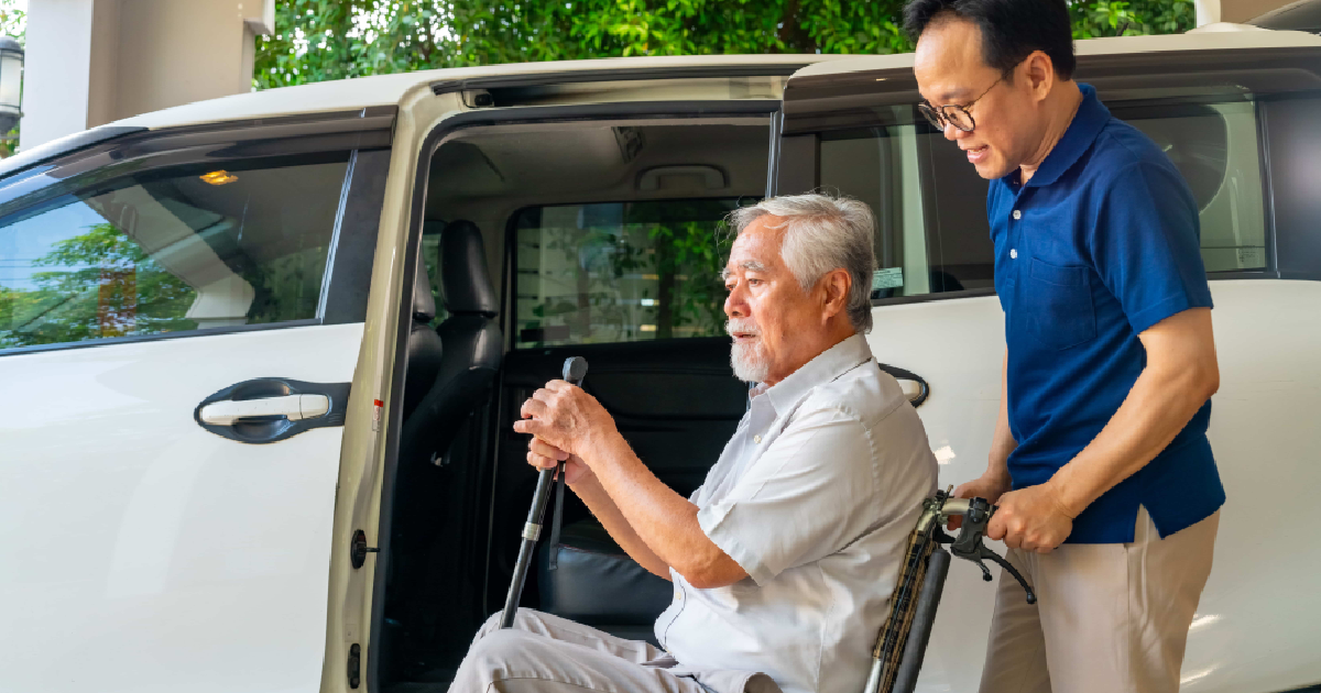 A caregiver assisting an elderly man into a car representing Skilled Care Transportation in Pearl River, NY.